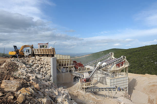 "Stone quarry with silos, conveyor belts and piles of stones"